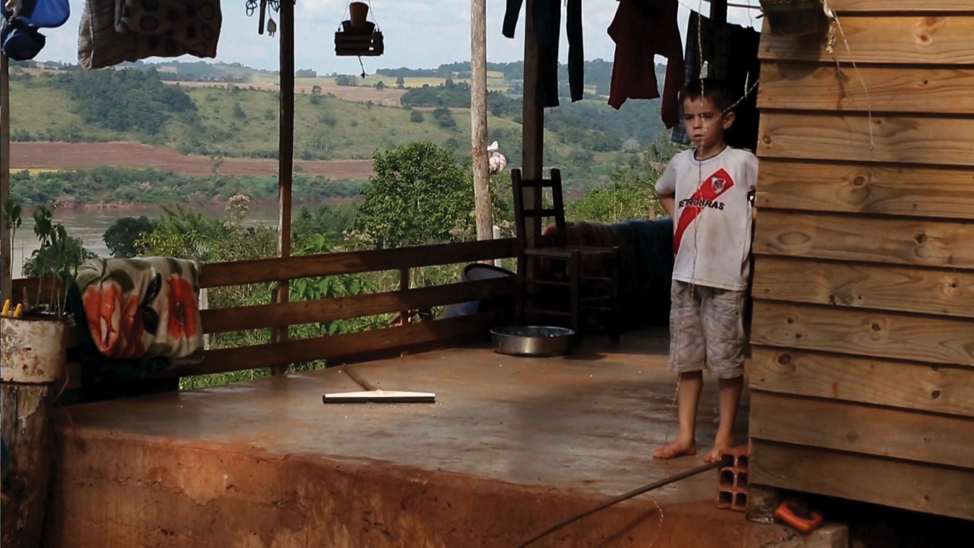 Genetically Modified Children Child sick from Roundup disease stands on porch of tobacco farm in Argentina